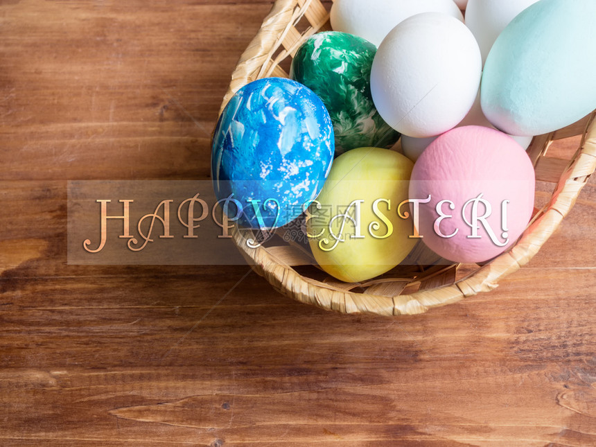 传统的季节一篮子复活鸡蛋在木背景上带着快乐复活节的文字橙图片