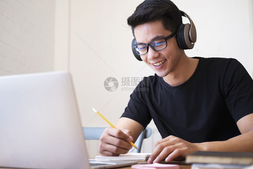 男青年学生在家用电脑上网学习图片
