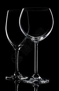 玻璃器皿黑色背景上两个空葡萄酒杯反射红图片