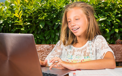 年轻的人们眼睛10岁的漂亮女学生在计算机上学习的幸福快乐图片