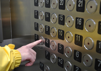 女人在电梯上按三个钮手裁剪正方形图片
