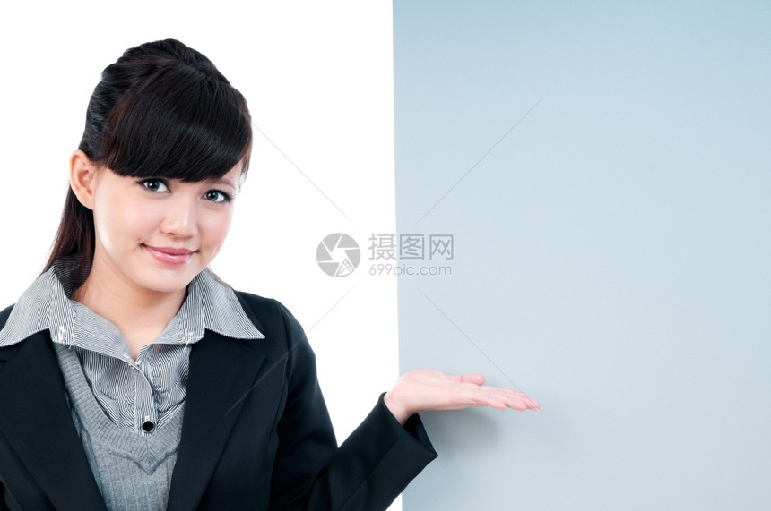 空的美丽一位可爱年轻商业女人在白色背景的空广告牌上露面的肖像愉快图片