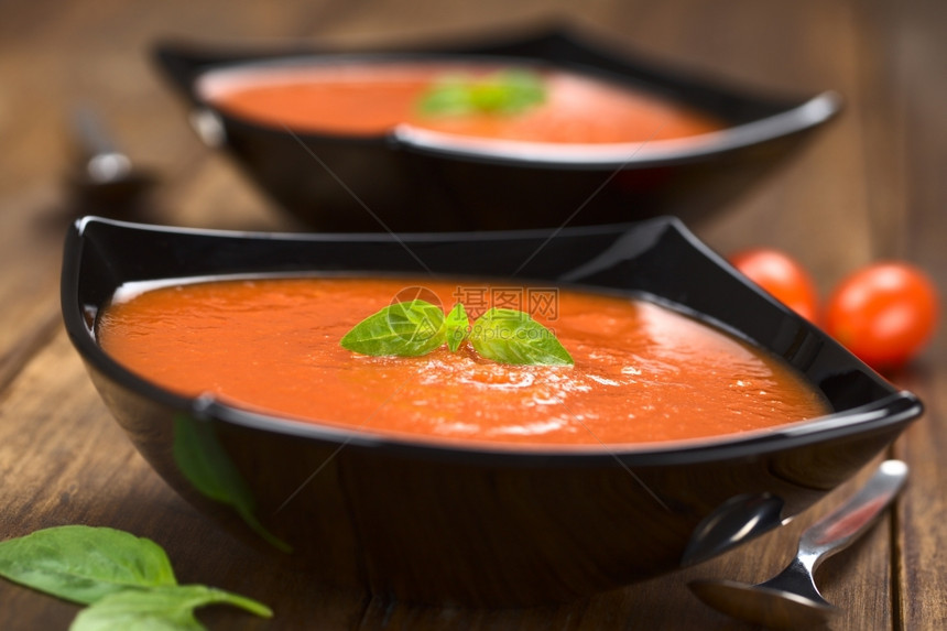 木头送达土制新鲜番茄汤上面有叶在黑碗中用喂木选择焦点关注番茄汤上的叶热图片