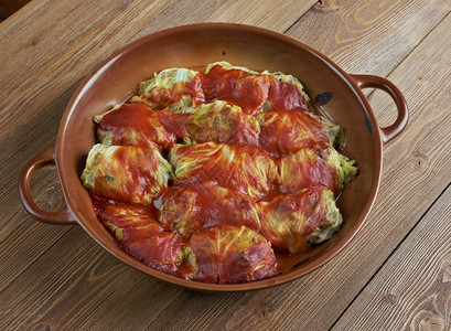 住棚节卷心菜Holishkes传统的犹太菜卷土豆碎屑叶用包裹式装的方在肉和番茄酱上红色的美食背景