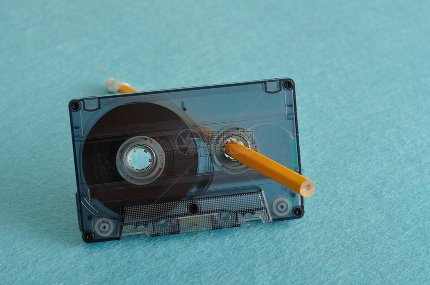 复古的老董一张旧磁带铅笔的录音在蓝色背景上被隔离图片