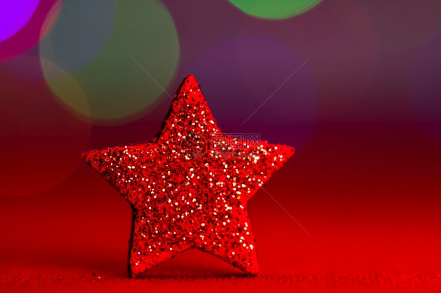 红色的闪光装饰品由丰富多彩的圣诞节构成隔绝在模糊灯光背景上季节礼物庆祝图片