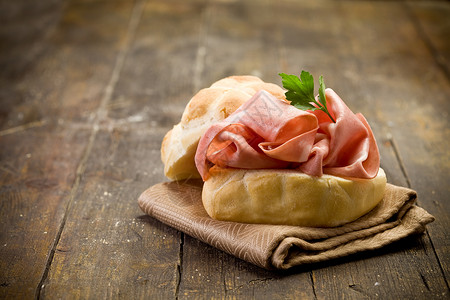 首发桌子木制餐上美味的三明治和薄荷香肠意大利语艾米亚背景