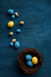 美丽的在蓝布底Paschal食物活动装饰春季假日庆祝活动标志和蓝底装饰蜂巢中的复活节鸡蛋装饰蜂巢的复活节鸡蛋象征庆典背景图片