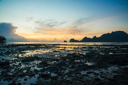 土地在海滩上日出山地和树林的沙滩上风景泰国图片