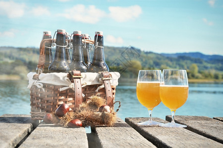 小包农村喝在木制码头对着湖边的啤酒图片