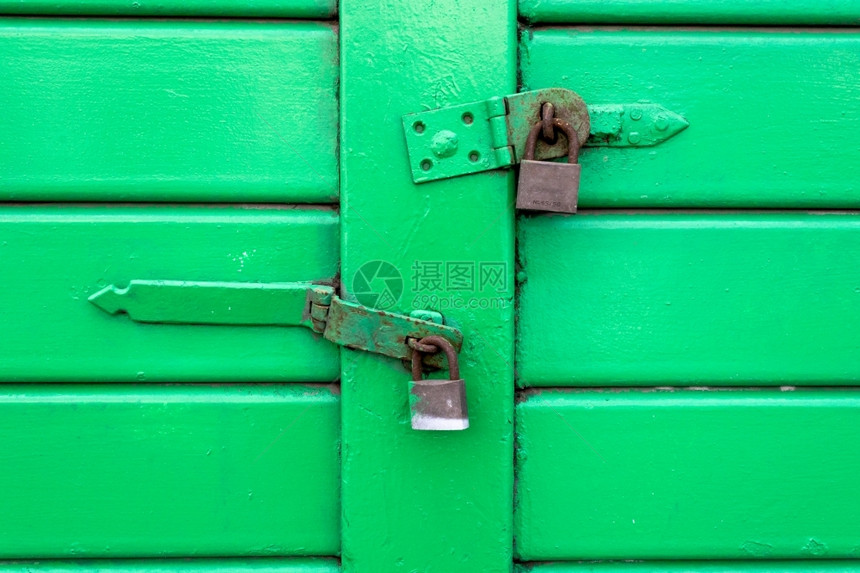 安全保护用挂锁住的绿色木板门车库图片