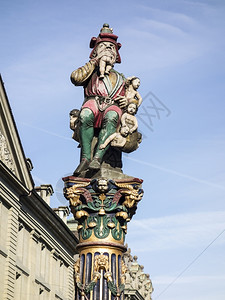 孩子们故意的更多瑞士伯尔尼Kindlifresserbrunnen喷泉雕塑描绘着一只坐的食人怪吞一个婴儿和袋更多孩子的154年H背景图片