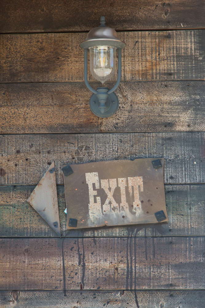 方向在Ventage油灯出口标志和Wintage油灯附近的Wooden框架箭头上的退出信号和绿箭色单词图片