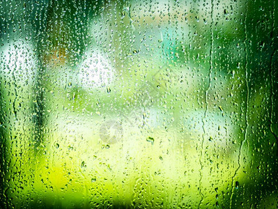 蓝色的下着绿叶和树底的玻璃雨下水滴落在玻璃上喷抽象的图片