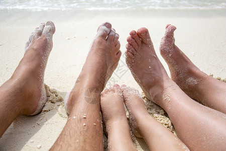 薪满意足闲暇松弛母亲父和子女在海边沙滩上伸展脚足华丽的背景