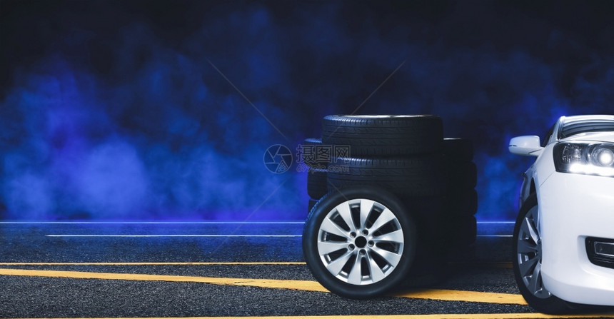 商业沥青路上的轮式和胎堆积在沥青路上夜晚有黑色背景的蓝烟雾修理轮缘图片