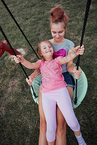 女孩粘合花园少在后院的一家庭操场上与妹玩耍快乐笑的姐妹们在夏日一起秋千玩得开心真人情背景图片