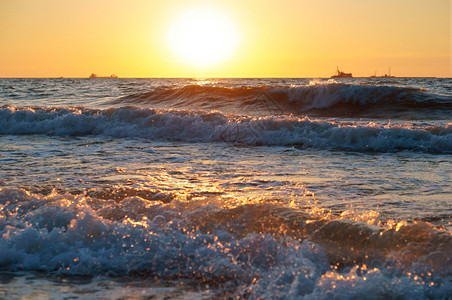 海滩上日落浪中的出上落浪漫风景图片