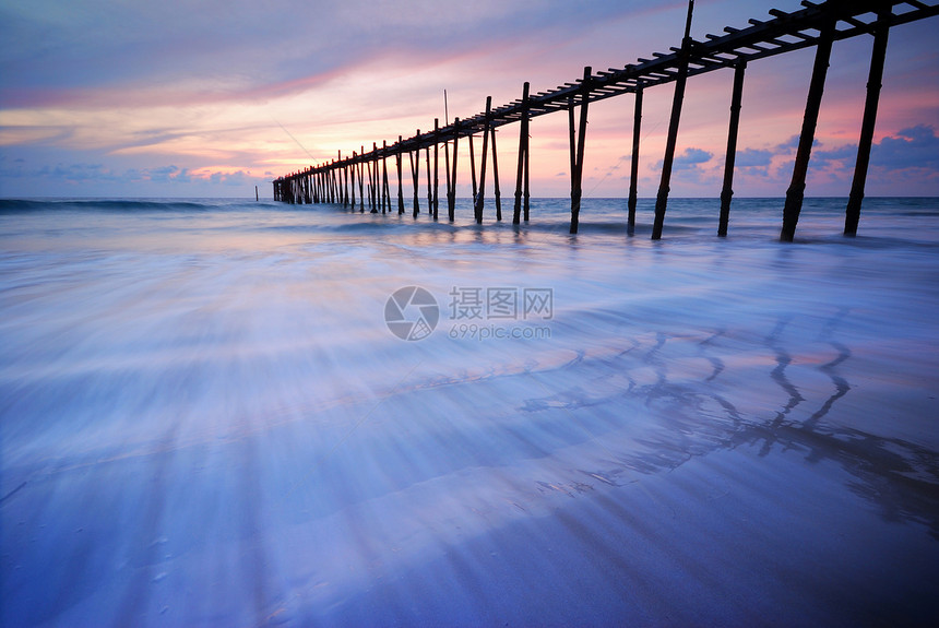 沙滩日落后进入大海的木桥蓝色美丽季节图片