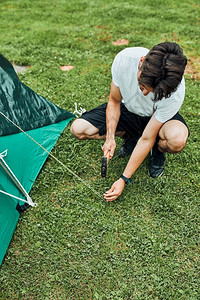年轻人在暑假旅行搭帐篷露营图片