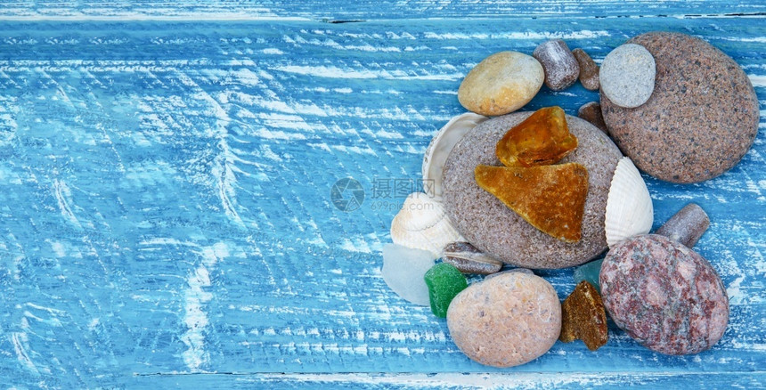 桌子上的海卵石和贝壳蓝色背景上的海石金字塔桌子上的海卵石和贝壳俄罗斯冥想放松图片