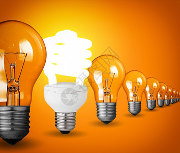 生态发光的家庭用橙色背景的灯泡构思概念图片