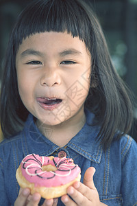 在吃甜甜圈的小女孩图片