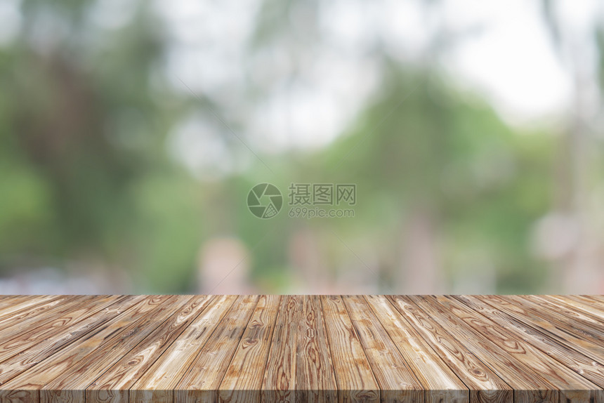 明亮的桌面花园绿色模糊背景上的空木板桌顶头图片