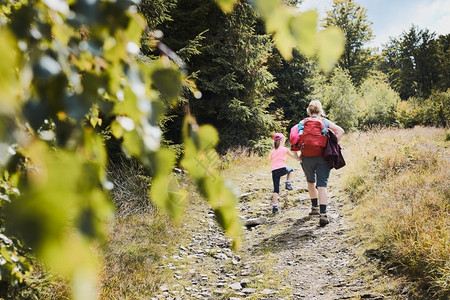 积极地春天娱乐母亲与小女孩一起在山上徒步积极共度暑假图片
