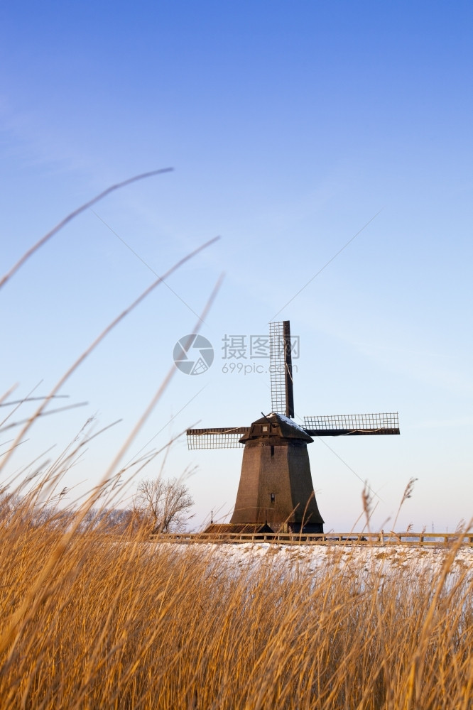 刀欧洲的著名冬季风车有雪和蓝天空图片