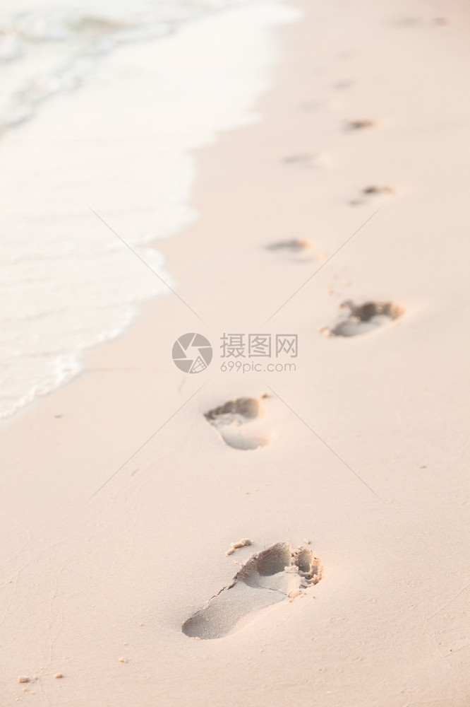 在海边滩上行走的人们脚足迹印在沙滩上的脚海滨浪漫平静图片
