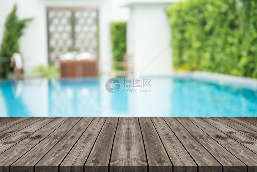 老的前面空木板桌游泳池背景模糊不清游泳的松树图片