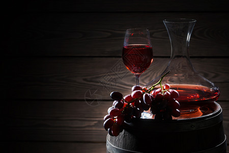 地窖木头一种红酒和串葡萄在木桶上红酒和一堆葡萄在桶子上图片