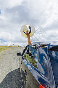 自驾游人们蓝色的女手举着帽子从车窗外伸出来图片