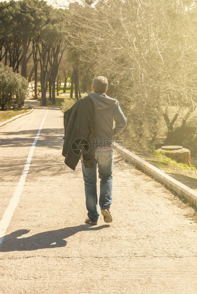 黑色的青年男子在农村公路上行走颜色背部图片