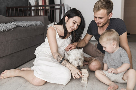快乐家庭与狗一起玩木偶塔游戏自然人们木头图片