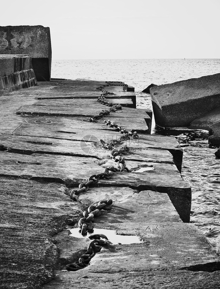 金属黑色和白混凝土码头的船锚用旧生锈铁链贴近画面白色的海洋图片