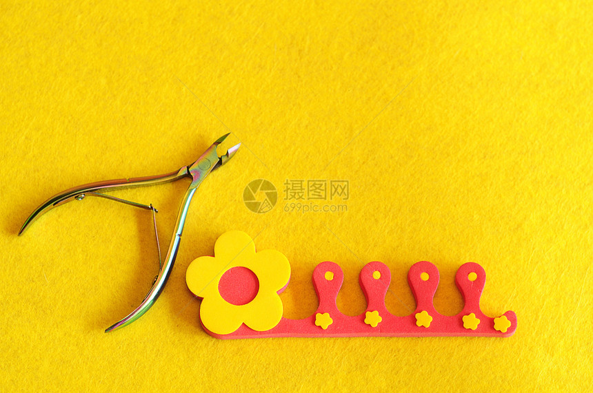 表皮配饰黄色背景的指甲剪刀和脚趾分离器产品图片