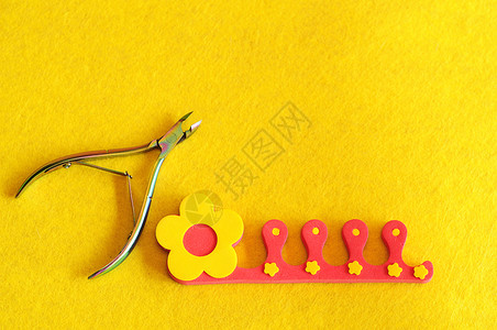 表皮配饰黄色背景的指甲剪刀和脚趾分离器产品图片