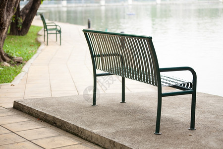 游泳板排成一在公园休息非正式的黑色长椅图片