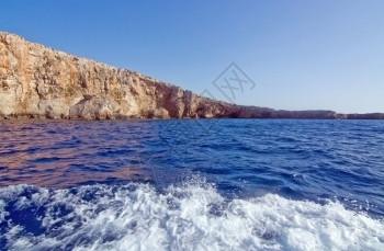游客船在马耳他科米诺岛附近有山洞和蓝地中海洋水的利姆斯通岩石气候图片