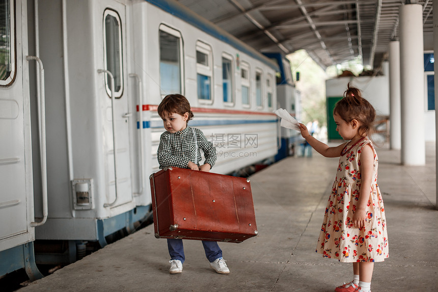 优质的铁路在小火车站穿着旧衣服和式手提箱的男女小孩和少爱图片