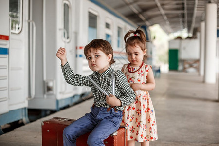 在小火车站穿着旧衣服和式手提箱的男女小孩和少优质的铁路游客图片
