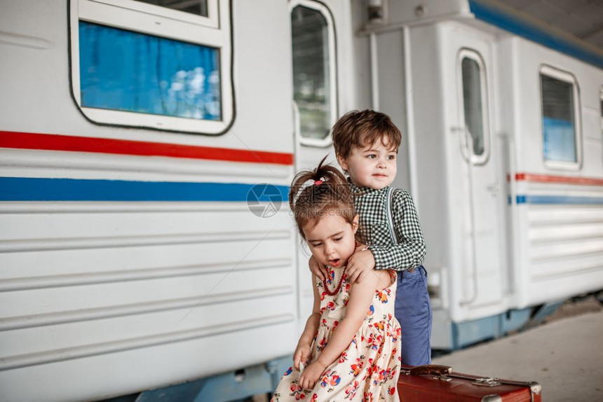 旅游再见在小火车站穿着旧衣服和式手提箱的男女小孩和少快乐的图片
