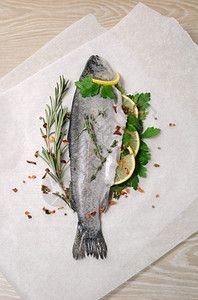 纸上加柠檬和香料的新鲜鳟鱼营养早餐平衡图片