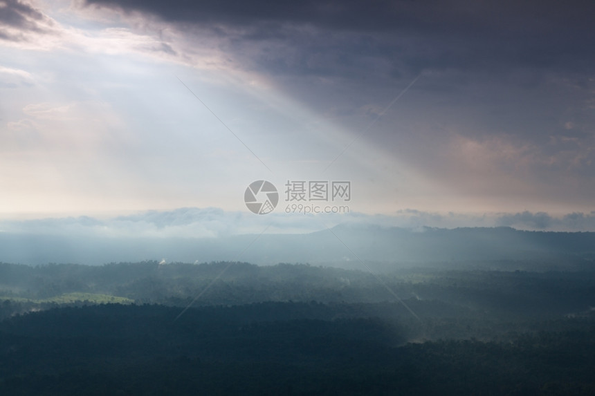 秋天日光照耀着云彩吹入山丘和森林雾笼罩的山岳和树木自然轮廓图片