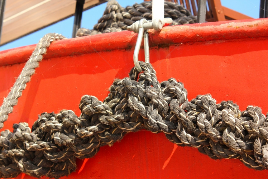 垃圾摇滚在一条红船上紧贴着一条旧的磨碎船绳捻老图片