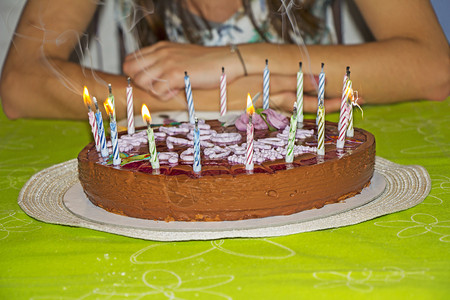 庆典年轻女孩要吹蜡烛在她的生日蛋糕上食物巧克力图片