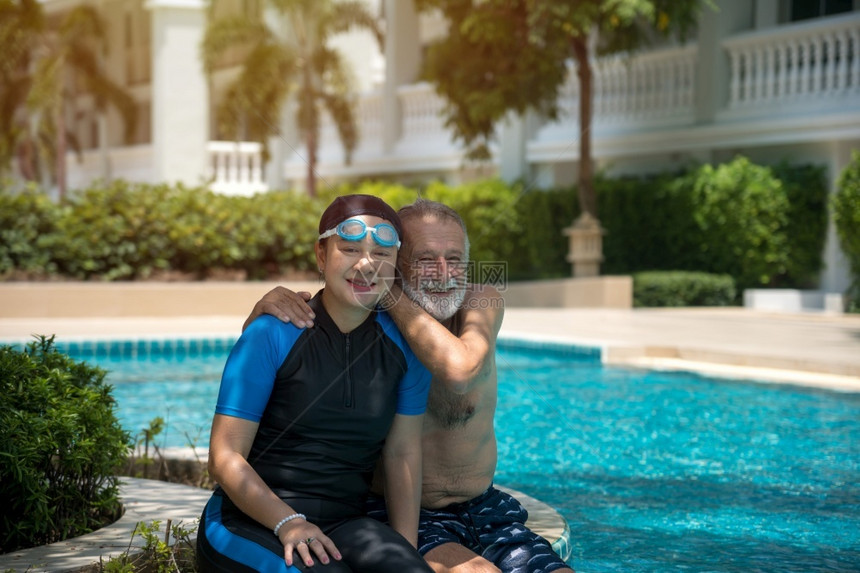 水池丈夫老年妇在游泳池共中放松户外图片