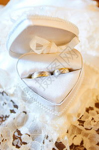 结婚戒指的心胸枕头金子白色的婚礼图片